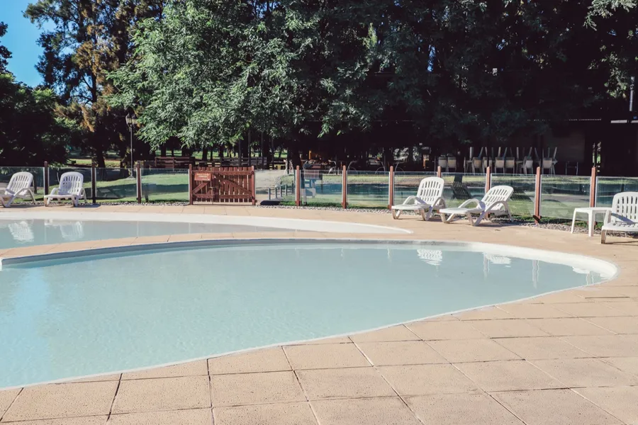 Solárium con reposeras junto a la piscina
